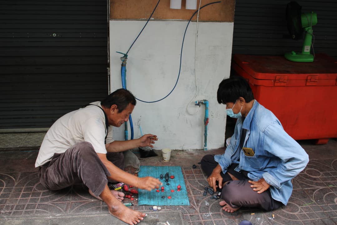 Thai men playing chess on the ground, Bangkok Thailand